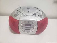 Front view of silver and red CD boombox showing speakers, LCD display and controls
