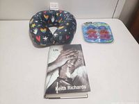 All three items together: book, neck pillow, sealed goggles pack