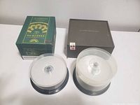 Lot overview showing two CD spindles, green H. Upmann cigar box, brown John A. Stevens box