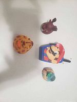 Four small toys laid out on white surface