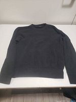 Front view of dark Karbon sweater laid flat