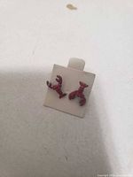 Front view of red lobster-shaped stud earrings on display card