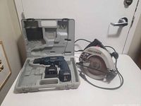 Cordless drill kit with two batteries in case beside Craftsman circular saw