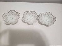 Three matching clover-shaped bowls lined up