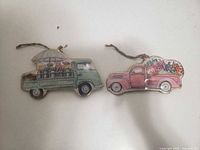 front view of both metal truck ornaments with twine hangers