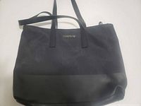 Front view of black Cosmopolitan tote with handles visible