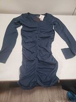 Front view of dark blue ruched long-sleeve shirt