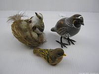 Overview of three bird figures: wood sparrow, wood quail, plastic nest with birds and eggs