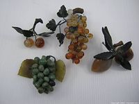All four carved stone fruit pieces displayed on white background