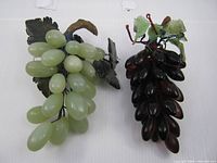 Light green and dark purple grape clusters side by side showing full shape and color