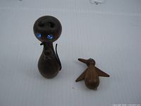 Cat figurine standing next to bird brooch