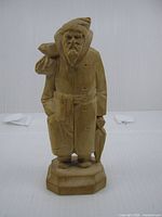Front view of carved wood elderly man figure