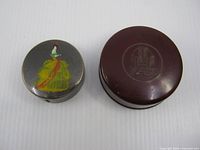 Top view of compact with dancer design beside Kado jar