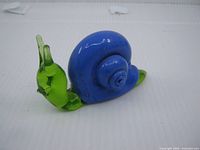Left side view of blue and green glass snail