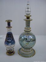 Two Egyptian glass perfume bottles side by side showing relative sizes and designs