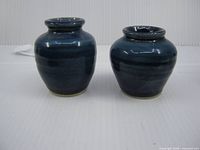 Front view of both small blue glazed vases