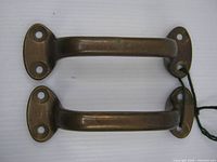 top view of both bronze handle pulls showing mounting plates and patina