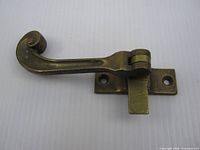 Brass casement latch showing lever and mounting plate front view