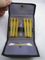 Opened case showing pegs, glass tensioner, and interior fabric