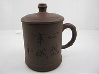 Front view showing calligraphy, handle, lid