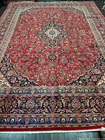 Full view of the Kashan rug showing overall pattern and borders