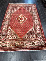 Full view of handmade Persian Arak wool rug on dark floor