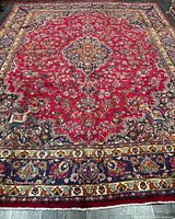 Full view of handmade Persian rug showing overall design and borders