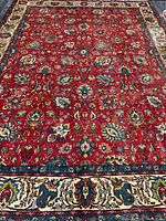 Full view of red Persian rug with floral design
