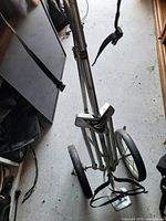 Overall view of folding two-wheel golf push cart with metal frame and 325 sticker