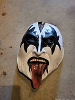 Front view of Gene Simmons style full-face mask showing paint scheme, tongue, and wear.