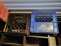 Black and blue plastic milk crates on shelf