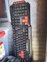 Full view of MINIBIRD full-size wired keyboard showing red accent keycaps and attached USB cable