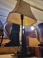 Full view of mission-style black metal table lamp with cream fabric shade