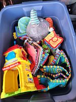 Overall lot view inside storage bin showing all toys