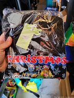Front of sealed black Christmas top showing CHRISTMAS text and character graphics