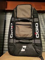 Front view of Ogio carry-on showing logo, zip pocket and fabric panels