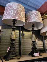 Front view of both matching table lamps with patterned fabric shades and dark metal bases