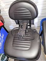 Black padded swivel seat with charger resting on seat