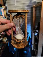Full view of rustic wood hourglass with white sand