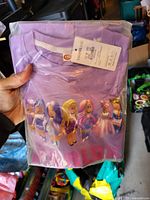 Front view of lavender THOMLUE children’s T-shirt in sealed bag showing Roblox characters graphic and hang tag indicating size 150