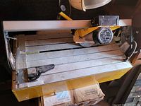 Top view of wet tile saw showing cutting bed, motor, blade and fence