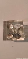 Top view showing five embedded coins in acrylic block