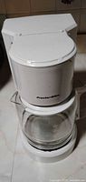 Front view of white Proctor Silex coffee maker and glass carafe