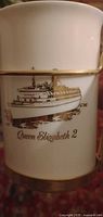 Mug upright showing QE2 ship decal, gold trim and metal handle