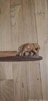 Side view of teak elephant on shelf base