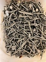 Top view of loose 2-inch roofing nails filling bucket