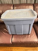 Overall view of blue Rubbermaid tote on couch, lid closed