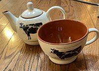 Teapot and cup side by side showing exterior graphics and interior color