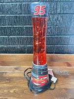 Front view of Lightning McQueen glitter lamp with cord coiled