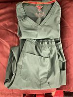 Scrub top folded with matching pants showing pockets and waistband